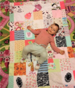 dziecko leży na kocyku patchwork